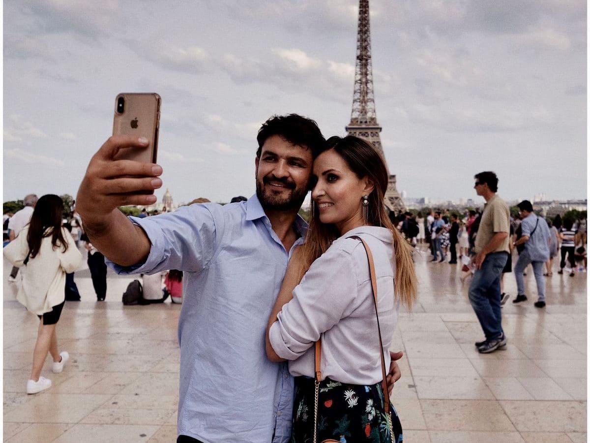 Travellers taking a photo in front of the Eiffel Tower in Paris
